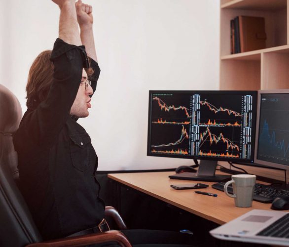 young-stock-trader-stretching-hands-at-workplace-h-8MJUT68 young-stock-trader-stretching-hands-at-workplace-h-8MJUT68